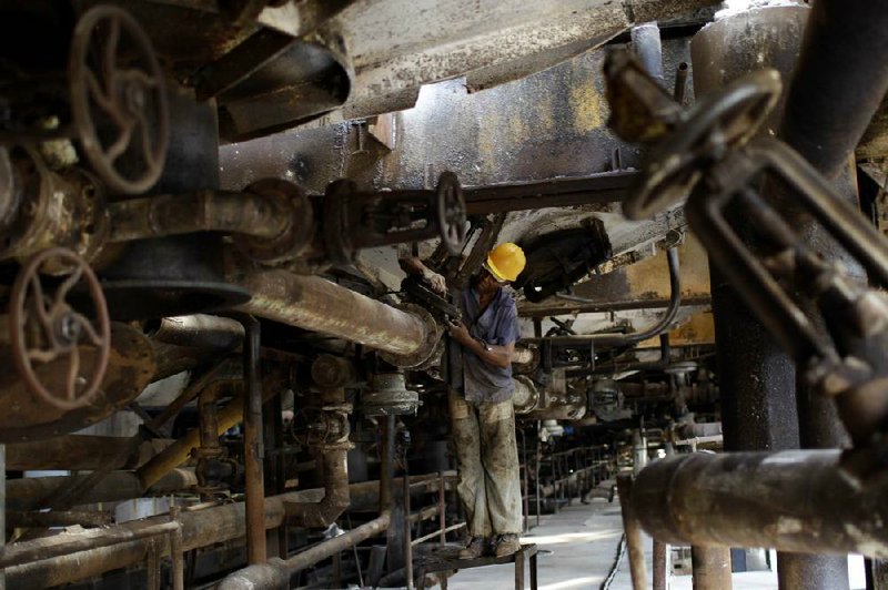 Guillermo Castillo, 60, works on a valve that regulates the passage of sugar cane juice at the sugar processing plant Brasil in Jaronu, Cuba, earlier this month. The Brasil plant is getting a makeover as the country jump-starts its sugar industry. 