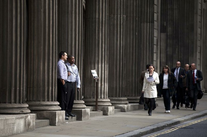 Pedestrians pass the Bank of England in London on Friday. Britain’s Financial Services Authority released a plan that calls for tougher controls on banks involved in the calculation of the London Interbank Offered Rate. 