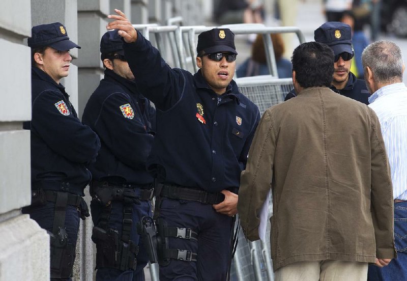 Police guarding the entrance to the Spanish parliament in Madrid direct pedestrians earlier this week before a protest against the government’s handling of the economic crisis. 