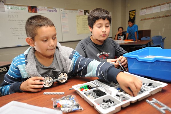 Jose Mancia, left, and Axel Lopez, both sixth-graders at Sonora Middle School, work Thursday to assemble a Lego robot meant to eventually use a robotic arm to perform tasks as a part of the school’s Outreach program.