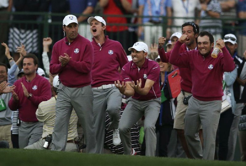 European players celebrate as Ian Poulter makes a putt to win on the 18th hole during a four-ball match at the Ryder Cup on Saturday. Poulter and his partner Rory McIlroy defeated Jason Dufner and Zach Johnson 1-up. The United States leads 10-6 going into today’s singles competition. 