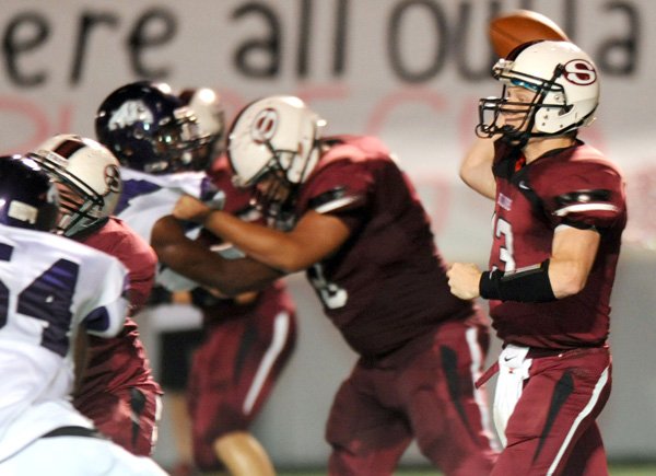 Springdale senior quarterback Will Whatley, right, looks to pass through the Fayetteville defense Friday, Sept. 28, 2012, during the first half of play at Jarrell Williams Bulldog Stadium in Springdale.