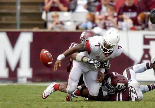 NWA Media/JASON IVESTER -- Arkansas running back Knile Davis fumbles the ball while being tackled by Texas A&M defensive lineman Damontre Moore (left) and linebacker Steven Jenkins during the third quarter on Saturday, Sept. 29, 2012, at Kyle Field in College Station, Texas.