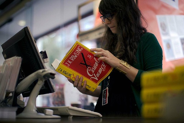 An employee looks at a copy of The Casual Vacancy, J.K. Rowling’s long-anticipated first book for adults, at a bookstore in London on Thursday. Publishers tried to keep details of the book under wraps ahead of its release, but The Casual Vacancy has gotten early buzz about references to sex and drugs that might be a tad mature for the youngest Potter fans. 