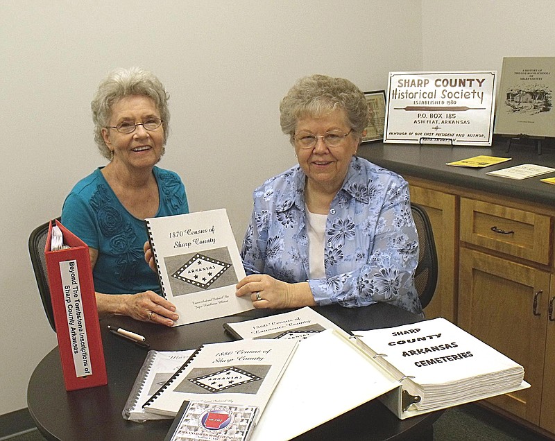 Eva Royal, left, secretary of the Sharp County Historical Society, accepts a book with Sharp County genelogical information from Joayce Hambleton Whitten for the society.