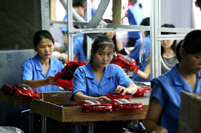 Employees work on a production line at a toy factory in China. 