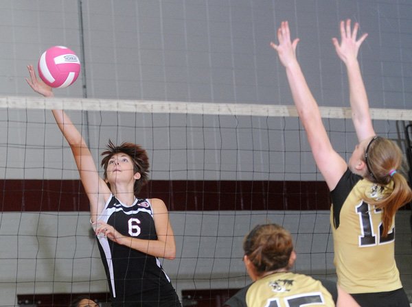 Mariah King, left, Springdale High, tries to put the ball over the block by Sabrina Shepherd of Bentonville on Thursday at Bulldog Gymnasium in Springdale. The Lady Tigers of Bentonville swept the Lady Bulldogs in straight sets. 