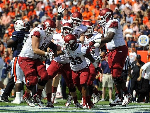 Arkansas running back Dennis Johnson celebrates with teammates after scoring a touchdown against Auburn on Saturday, Oct. 6, 2012 in Auburn, Ala.(AP Photo/Todd J. Van Emst)