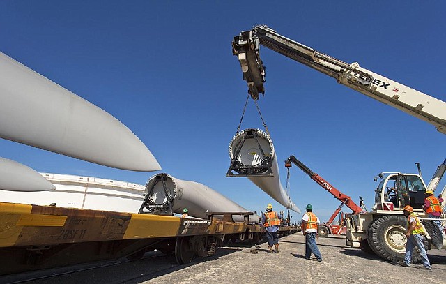 Workers load a wind turbine blade onto a rail car at the port in Corpus Christie, Texas, last month. Work on some U.S. wind industry projects has stalled as investors wait to see whether a federal tax credit for wind power is extended. 
