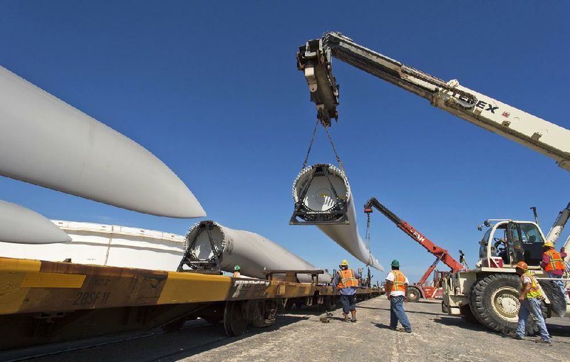 Workers load a wind turbine blade onto a rail car at the port in Corpus Christie, Texas, last month. Work on some U.S. wind industry projects has stalled as investors wait to see whether a federal tax credit for wind power is extended. 