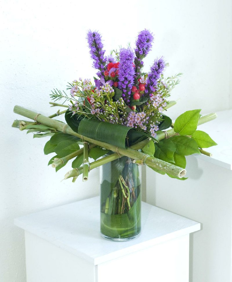 A hand-tied arrangement of flowers features a bamboo armature. 