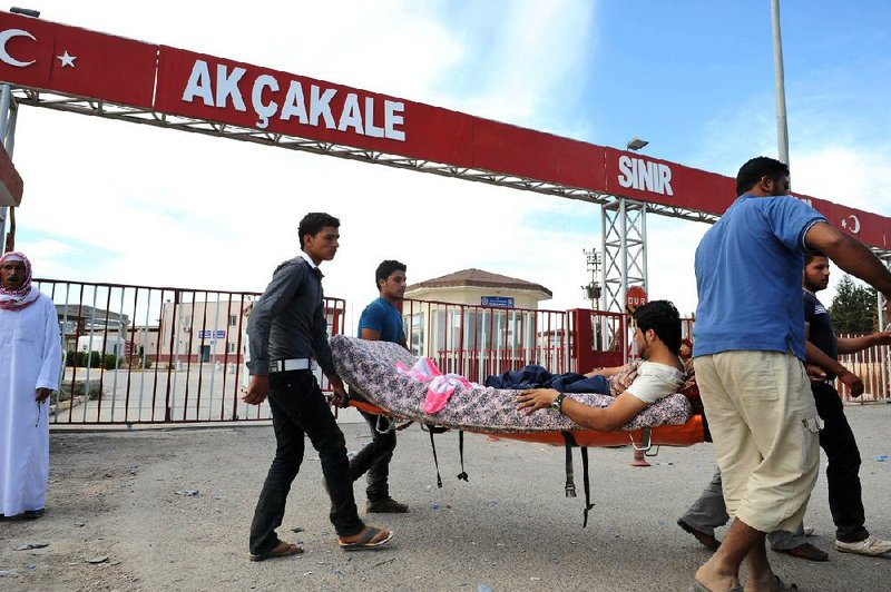 A Syrian rebel injured in fighting with government forces is carried out of the Syrian town of Tel Abyad across the border to the Turkish city of Akcakale. A Syrian mortar round landed inside Turkey on Friday, prompting Turkish troops to return fire