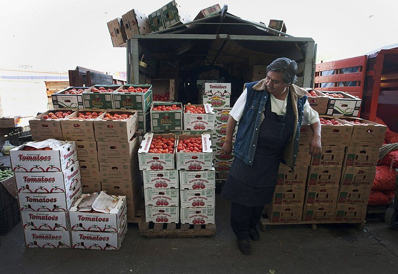 A seller looks at boxes of tomatoes at the Central de Abasto, Mexico City’s main wholesale produce market, in the borough of Iztapalapa in April. A group of U.S. tomato growers are complaining that Mexico growers are unfairly exporting low-cost tomatoes north of the border. 