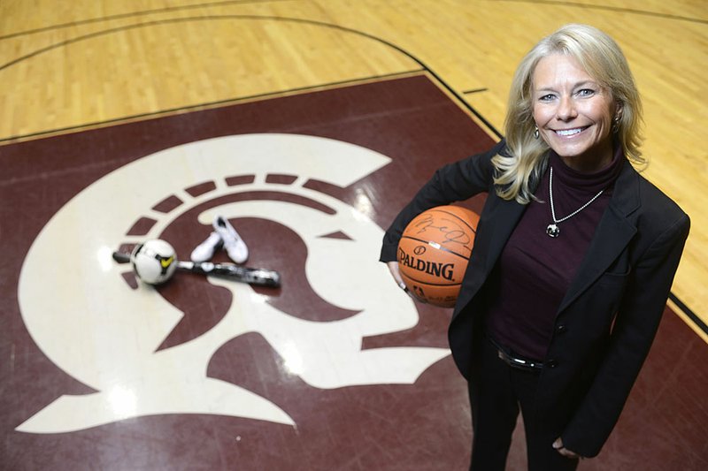 Jane Yocum holds an autographed Michael Jordan basketball, one of the items to be auctioned at SpectacUALR — A Benefit for Trojan Athletics on Thursday at the Jack Stephens Center. 