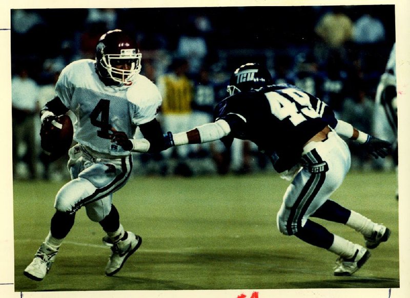 Former Arkansas quarterback Quinn Grovey (4) tries to avoide TCU’s Edward Galariz during the Razorbacks’ 41-19 victory in 1989, part of a 10-2 season for Arkansas in which it won the Southwest Conference championship. The following season, Grovey and Arkansas finished a disappointing 3-8. 