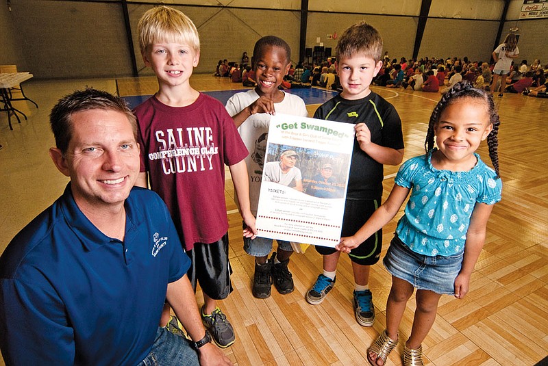 Boys and Girls Club of Saline County Executive Director Jasen Kelly is shown with, from left, Eli Kelly, Keaton Griffin, Hudson Chandler and Taylor McCoy hold a flyer advertising an upcoming fundraiser for the club that will feature “Trapper” Joe LaFont and “Trigger” Tommy Chauvin from Swamp People.