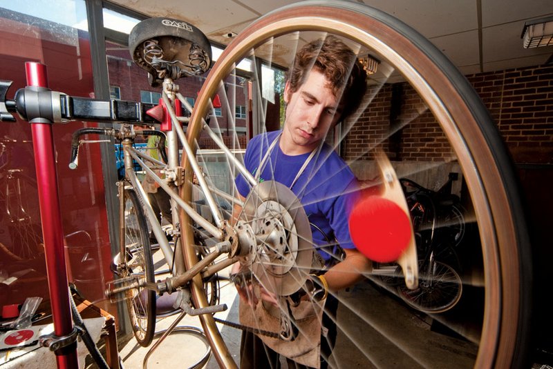 Hendrix senior Adam Grippo works on a bike at the student-run bike shop on campus. Grippo began repairing his own bikes in high school to save money.