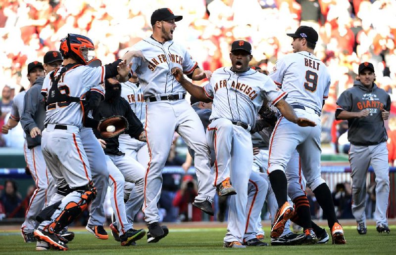 San Francisco catcher Buster Posey (left) celebrates with teammates after the Giants overcame a two-game deficit, beating Cincinnati 6-4, thanks to Posey’s fifth-inning grand slam. The Giants advanced to the National League Championship Series. 