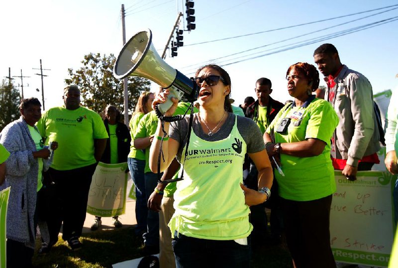 Kasi Farrar of San Francisco leads more than 100 people gathered Wednesday outside the Wal-Mart home office in Bentonville to protest working conditions at the retailer’s facilities. 