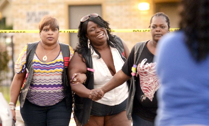 A woman reacts to the news of a relative that was killed at the Silver City Courts housing complex in North Little Rock on Wednesday. 