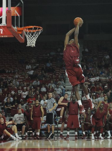 University of Arkansas basketball freshman Michael Qualls flies in the air during a dunking contest at Bud Walton Arena, Friday Oct. 12, 2012, as team mates look on during the Primetime at the Palace. 
