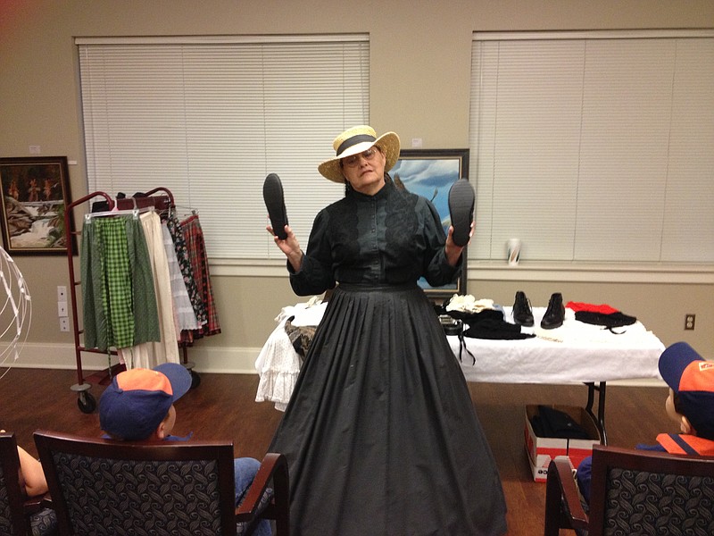 Dyan Bohnert, a Civil War re-enactor, shows a pair of slippers during a talk about Civil War apparel she presented at the Bob Herzfeld Memorial Library in Benton on Monday. 