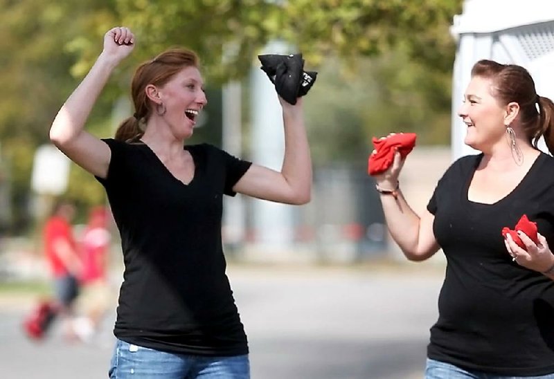 NWA Media/DAVID GOTTSCHALK

Melinda Francis (left), of Conway, celebrates a point as she plays bean bag toss with Melissa Myers, of Centerton Saturday afternoon in Fayetteville. The two were guests at Tim Myers, of Bentonville, and Ryan Myers, of Centerton, tailgate party before the University of Arkansas and University of Kentucky football game.
