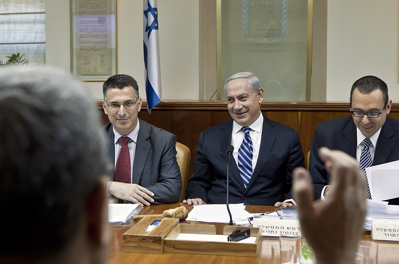 Israeli Prime Minister Benjamin Netanyahu, second right, laughs as Defense Minister Ehud Barak, back to camera, makes a joke that Netanyahu should give fair time to the opposition in political statements, as Netanyahu chairs the weekly cabinet meeting in his Jerusalem offices, Sunday, Oct. 14, 2012. Israel's Cabinet announced January 22, 2013 as the date for parliamentary elections, with Prime Minister Benjamin Netanyahu leading in the polls.