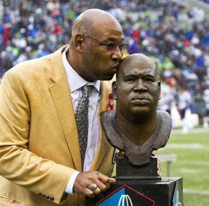 Wearing his Hall of Fame jacket, and his new Hall of Fame ring, Cortez Kennedy kisses the bust of his likeness that will be featured in the NFL's Hall of Fame  during halftime ceremonies Sunday Oct. 14, 2012, marking the retirement of his Seattle Seahawks jersey. (AP Photo/ The Seattle Times, Dean Rutz) 