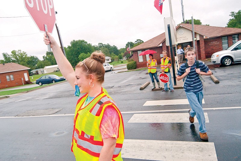 Erika Hampton, left, stops traffic to allow students to safely cross the road in front of Harmony Grove Elementary School in Benton.