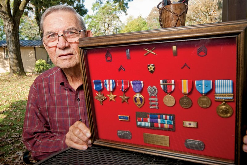 Walter Rhodes shows  the Distinguished Service Cross, Silver and Bronze Star and Purple Heart he earned while in the military.