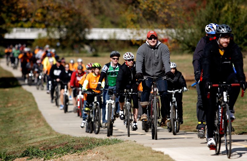 Cyclists make their way south along the newly opened section of the Razorback Greenway on Friday in south Rogers near the “Bridge to the Future.” The group started the ride at the Bentonville square. 