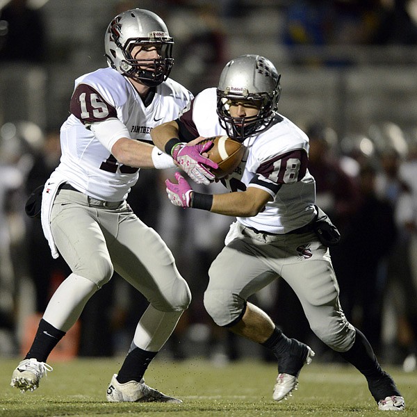 Austin Van Poucke, Siloam Springs starting quarterback, hands off to running back Scout Alexander during Friday’s game against Rogers at Mountie Stadium in Rogers. 