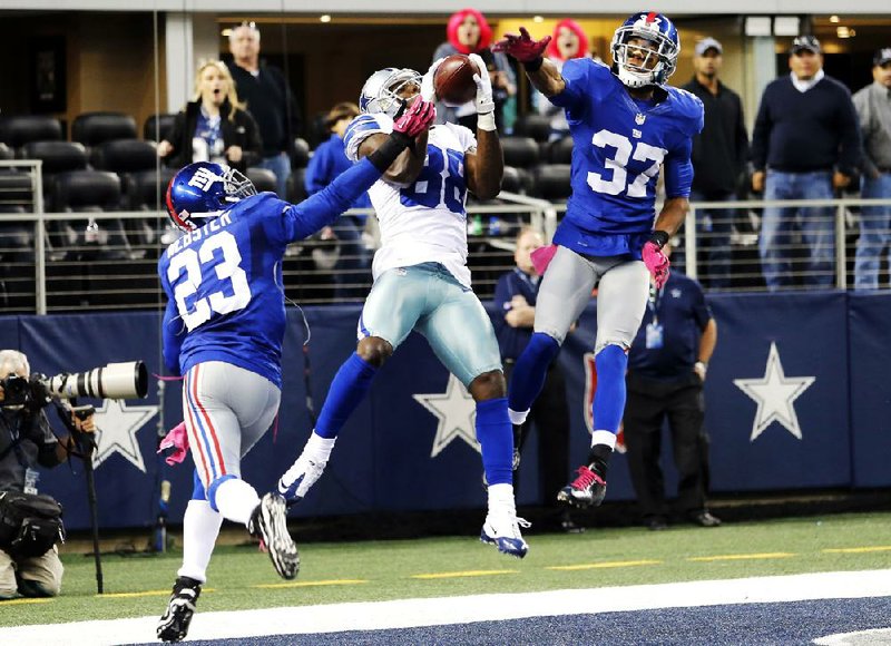 Dallas Cowboys wide receiver Dez Bryant (88) leaps to make an apparent catch between New York Giants cornerbacks Corey Webster (23) and Michael Coe (37) in the end zone with 10 seconds remaining in Sunday’s game against the New York Giants. The catch was ruled a touchdown on the field, but a review showed Bryant’s hand was out of bounds before securing the ball, and the Giants won 29-24. 