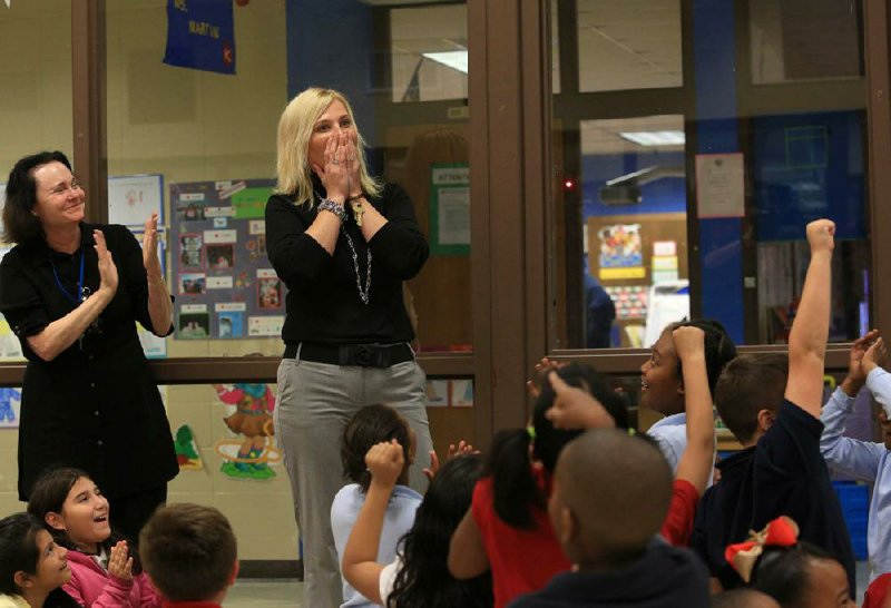 Zsuzsanna Diamond is taken aback and her pupils cheer after her name is called Monday at Otter Creek Elementary School in Little Rock as the winner of this year’s Milken Educator Award. 