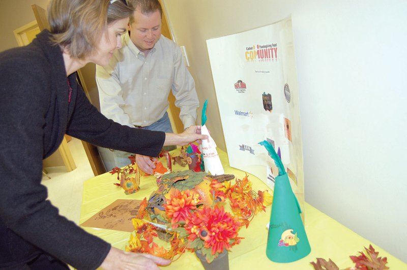 Heather and Dane Moore arrange a display advertising the upcoming Cabot Community Thanksgiving Feast.