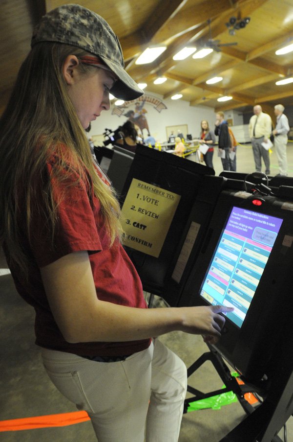 Peggy Sue Standridge votes for the first time Tuesday at the Rodeo of the Ozarks community center in Springdale. Standridge was among 15 Springdale High School seniors who cast their first ballot Tuesday. 