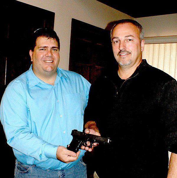 Gravette Mayor Byron Warren surprised retiring Police Chief Trent Morrison by presenting him the Glock 40 semi-automatic pistol which was the officer’s first weapon issued him by the Gravette Police Department. It was engraved with Morrison's name and the dates of his service — June 1991-November 2012. 