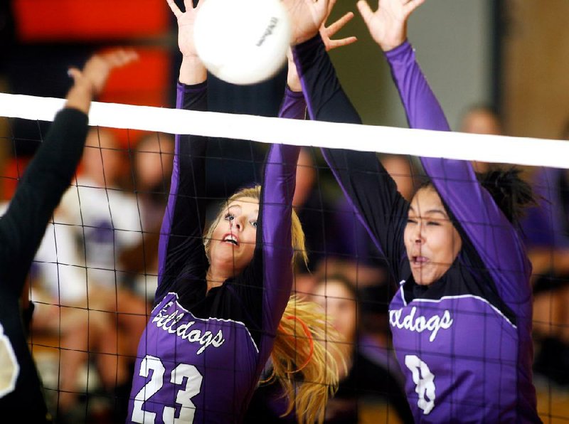 Fayetteville junior Cassidy Ginger (left) and senior Mikayla Avery attempt to block a Bentonville shot during their Class 7A semifinal match Thursday at Rogers Heritage High School. 