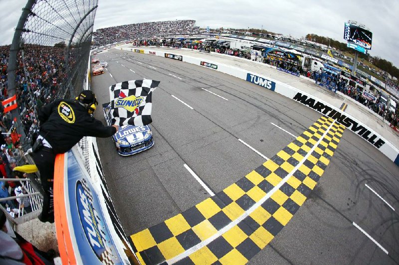 Jimmie Johnson crosses the finish line Sunday to win the Sprint Cup race at Martinsville (Va.) Speedway . The victory gave Johnson a two-point edge over Brad Keselowski with three races left. 