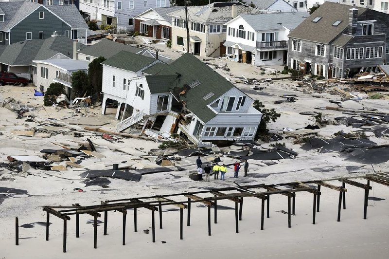 Damaged houses sit Wednesday near a walkway ripped away by Hurricane Sandy in Seaside Heights on a narrow barrier island that is part of New Jersey’s shoreline. More photos are available at arkansasonline.com/galleries. 