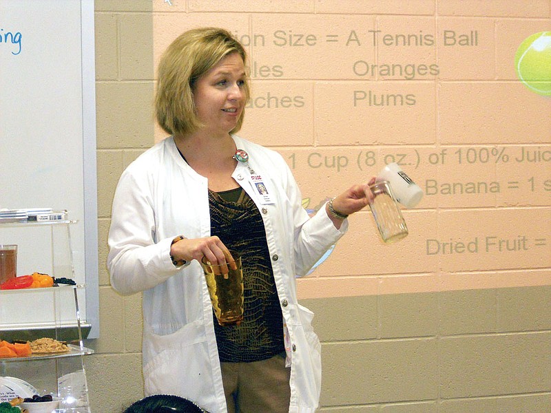 Erika Hixon, clinical dietitian with Hot Spring County Medical Center, explains which glass equals a serving to eighth-grade students at Malvern Middle School. Hixon is part of a project to teach the importance of nutrition and exercise in order to better prevent diabetes through weight control. 