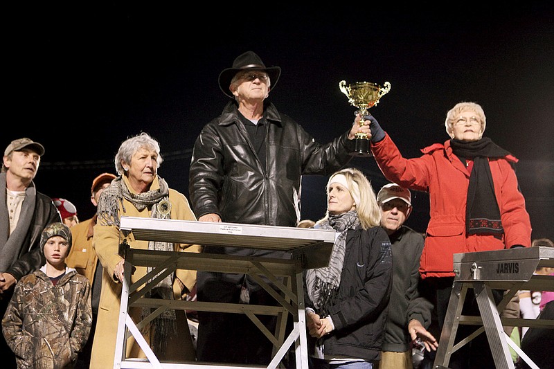 From the left, Peggy Roberson in khaki jacket, Charles Lewis Tull in black leather jacket and Marilyn Schick in red jacket, capture the spirit of C.W. Lewis Stadium during a ceremony after the final Benton High School varsity football game at the stadium on Oct. 26. They are grandchildren of C.W. Lewis and will release the spirit during the first football game at the new athletic complex.
