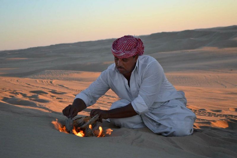 Being in the middle of the desert does not prevent safari driver Ahmed Bakrin from building a small bonfire to make mint tea before sunset. 