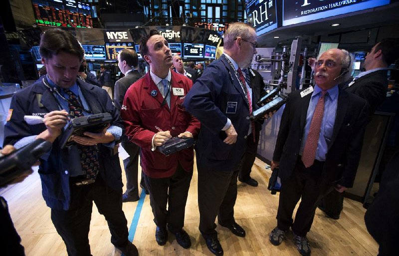 Traders work Friday at the New York Stock Exchange. Many stocks fell on the heels of Sandy. 