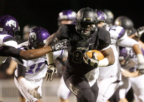 Tearris Wallace, a Bentonville senior running back, breaks through the Fayetteville defense during the first half on Friday at Tiger Stadium in Bentonville. 