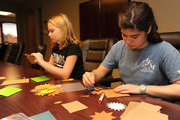 Maria Rossetti, 17, right, and Katie Morton, 10, demonstrate Wednesday the work members of the United Presbyterian Youth have been doing to create cards that will accompany gifts purchased at the Alternative Gift Market, from 9 a.m. to noon Nov. 11 and 18. The longtime market features gifts of donations to charitable organizations as well as free-trade items. 