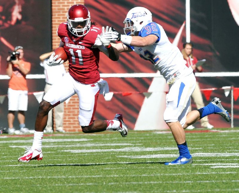 Arkansas receiver Cobi Hamilton (11) tries to fend off Tulsa defender Mitchell Osborne as he runs for 19 yards in the third quarter of Saturday’s game at Reynolds Razorback Stadium in Fayetteville. 