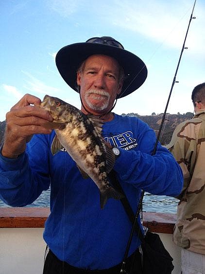 Jack Slemp of San Diego, an assistant on a charter boat that operates from a marina in San Diego Harbor, shows off a calico bass he caught near the mouth of the bay. 