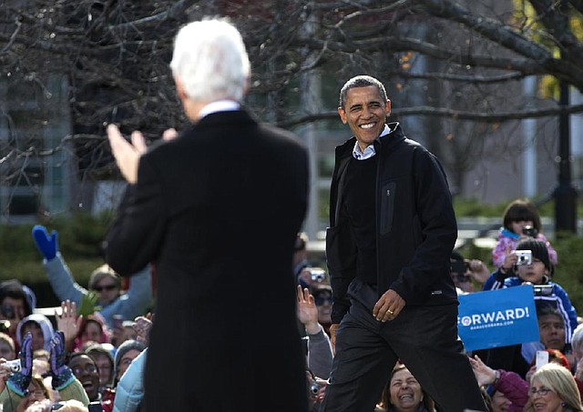 President Barack Obama (top) strides onto the stage as former President Bill Clinton applauds during a campaign event at State Capitol Square in Concord, N.H., on Sunday.